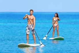 Family paddleboarding at sunset